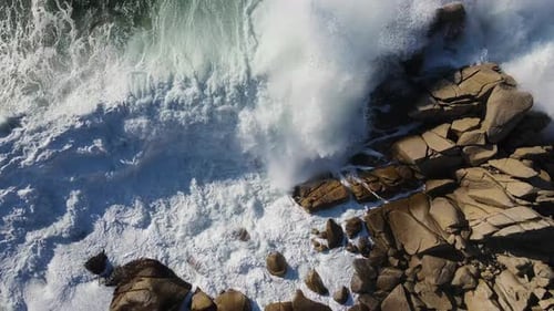 Slow Motion Topdown View of Powerful Storm Waves Rolling Onto the Rocky Shore