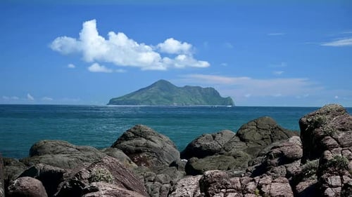 Blue sea and blue sky with changing white clouds. Small islands and rocks.