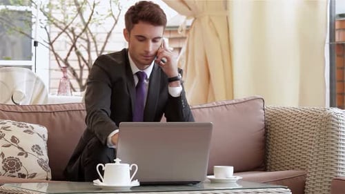 Focused Businessman Enjoying Espresso in a Chic City Cafe