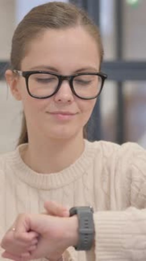 Woman with Glasses Uses Smart Watch Technology