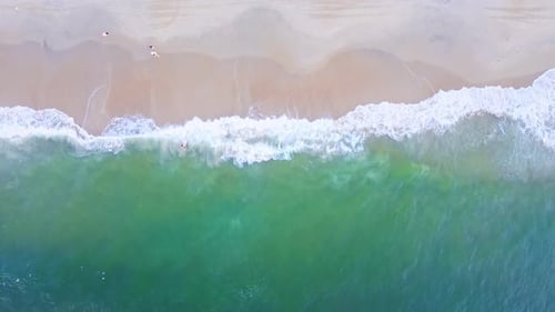 Aerial Top view of a transparent blue sea with beautiful waves at sunny day in summer. air of ocean