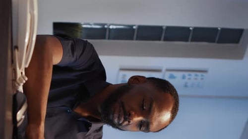 Vertikales Videoporträt eines disruptiven lächelnden CEO, der auf einem Laptop
