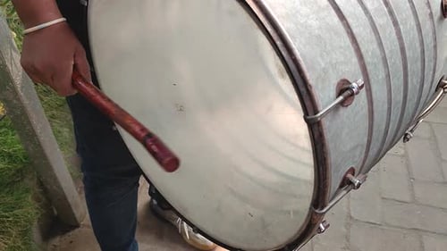 Gros plan du tambour joué avec un bâton à la main