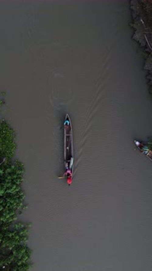 Vertical Drone Footage of Small Fishing Boats Floating on the River in the Forest