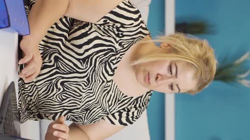 Woman Working with Laptop and Binder at Home