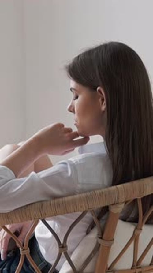 Upset Young Woman Looks Out of Window Sitting in Art Studio