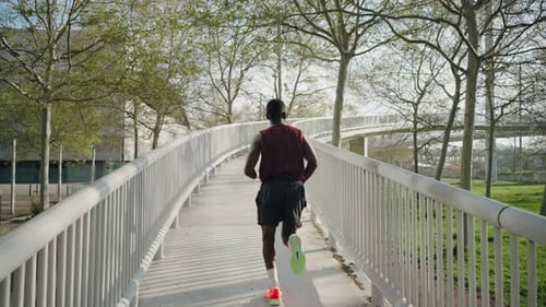 Man Running in the City Park Sport Training Crossing Modern Bridge