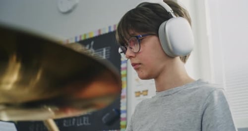 Focused Boy Practicing Drums at Home with Headphones