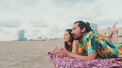 Romantic couple enjoying each other's communication while lying on blanket on the beach