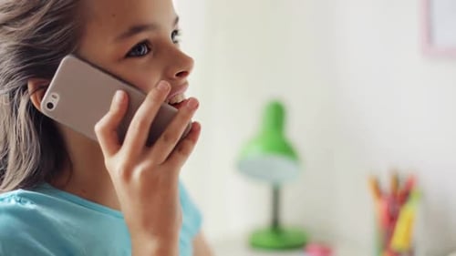 Smiling Girl Talking on Mobile Phone Indoors
