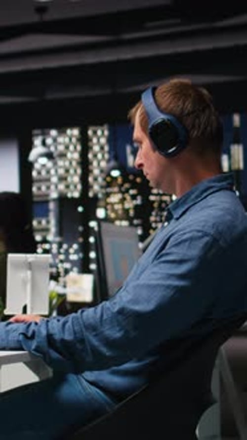 Man Working Late at Computer with City View