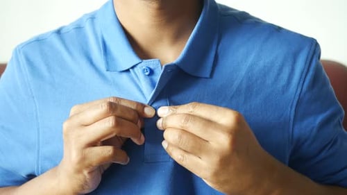 Man Buttoning His Shirt Close Up