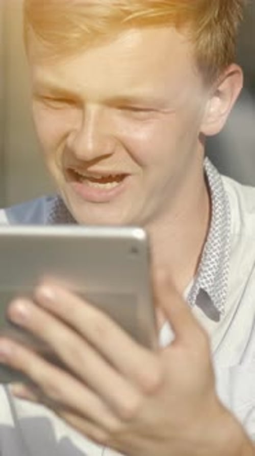 A Young Man is Focused on His Tablet in a Bright Cheerful Environment That Fosters Creativity