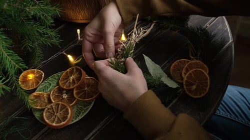 Festive Hands Crafting Holiday Wreath at Wooden Table