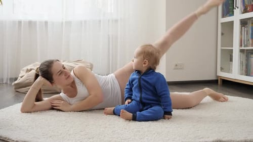 Woman Doing Leg Lifts with Baby Indoors