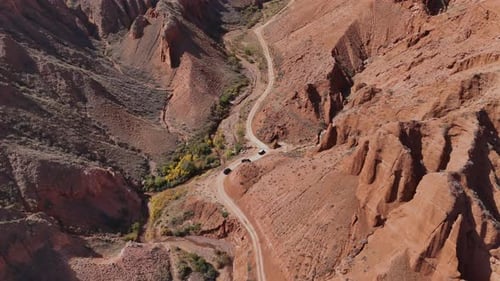 SUV Convoy Driving Through Red Cliffs in Konorchek Canyons