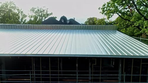 Presentación aérea lenta del techo de una casa de acero inoxidable de nueva construcción