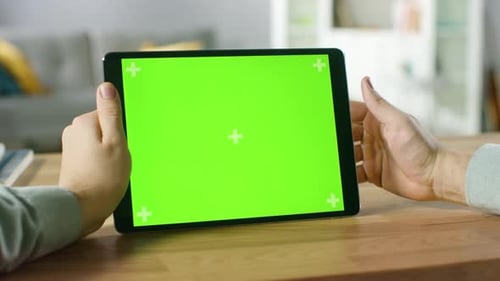 Nahaufnahme eines Mannes, der Handgesten auf einem digitalen Tablet-Computer mit grünem Modellbildschirm im Querformat verwendet