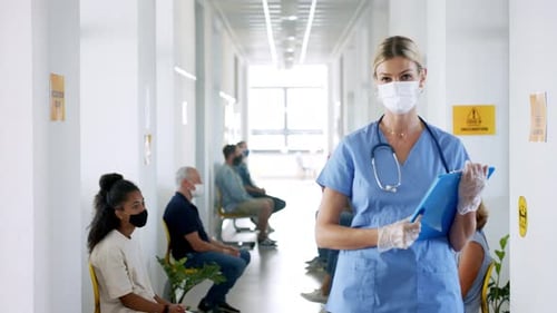 Healthcare worker stands in vaccination clinic waiting room