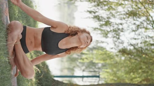 Woman Does Yoga Outdoors in Nature on Mat