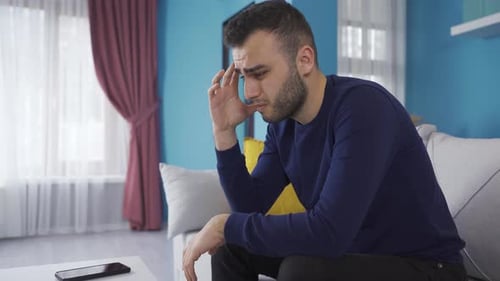Verzweifelter und unglücklicher junger Mann, der unter schlechten Nachrichten leidet.