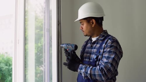 Man Repairing Window with Power Drill Indoors
