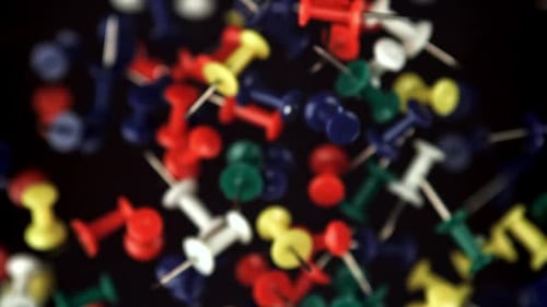 Colorful Push Pins Floating on Black Background