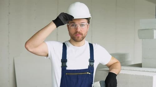 Porträt eines seriösen Baumeisters mit Schutzhelm auf der Baustelle des Büros