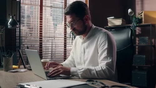 Man Working on Laptop in Modern Office