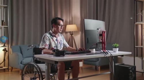 Adult Using Computer in Wheelchair at Home