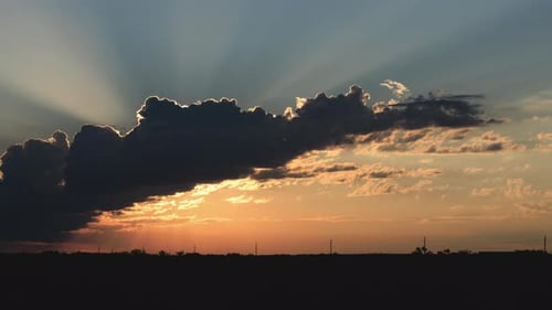 Golden Sunrise Bursting Through Clouds in Rural Landscape