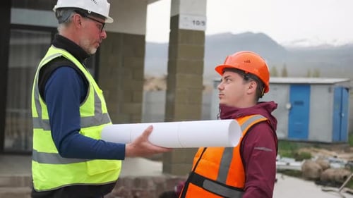 Men Discussing Construction Project Plans at Building Site