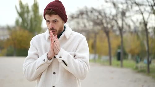 Man Coughing in Park on Cold Day