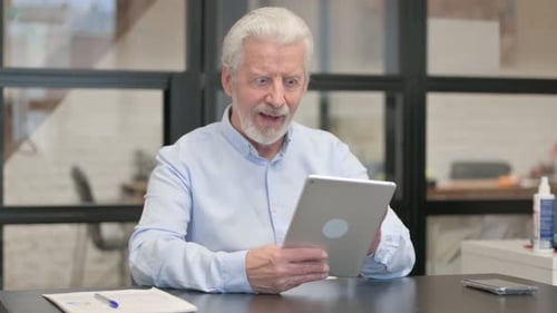 Old Businessman Celebrating Success on Tablet in Office