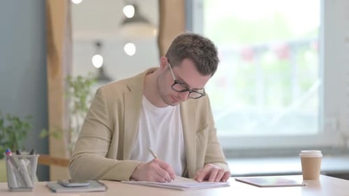 Young Businessman Doing Paperwork in Office