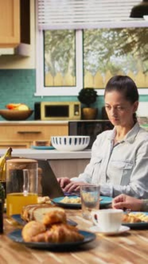 Vertical Video Busy Mother Ignoring Her Daughter at Breakfast and Focusing on Her Work
