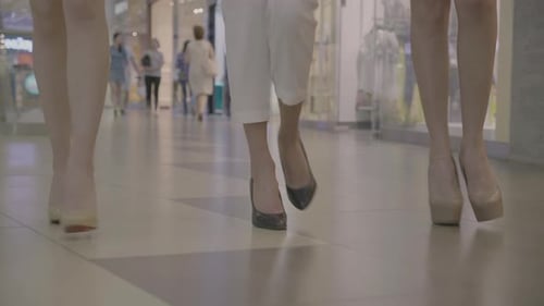 Drei gut gekleidete Mädchen, die nicht wiederzuerkennen sind, gehen durch das Einkaufszentrum und haben nur gesunde Beine