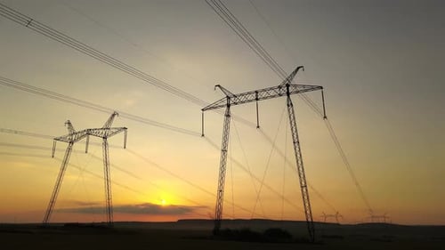 Electrical Pylons Silhouetted Against Rural Sunset