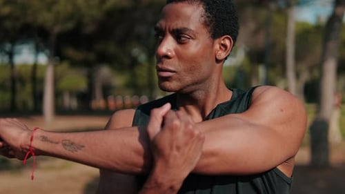 Fit Black Man Stretching in the Park