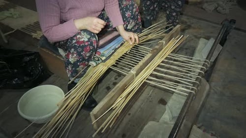 Woman Hand Weaving Reed Material on Loom