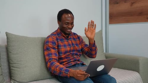 Young Adult on Couch Using Laptop