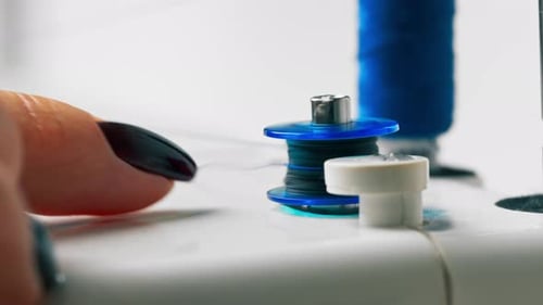Closeup in a Sewing Workshop on a Machine Winding Blue Thread on Drum for Sewing