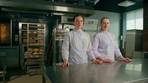 a team of smiling professional bakers in a professional kitchen in a bakery before the start baking