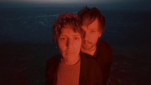 Portrait of Couple in Red Light against Frozen Lake at Night