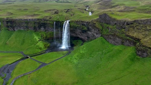 Majestic Seljalandsfoss Waterfall Cascading Down Cliffs in the Lush Green Landscape of Iceland