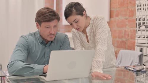 Man and Woman Discussing Project at Desk