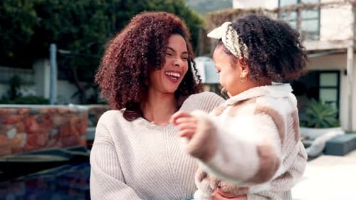 Laughing Woman Holding Child in Suburban Backyard