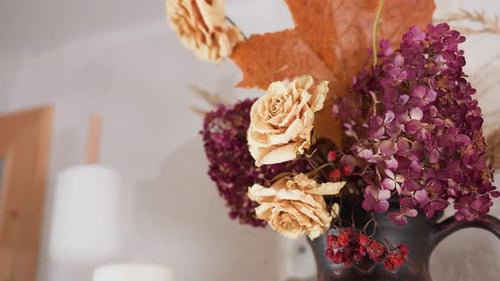 Close Up of Dried Floral Arrangement with Roses Hydrangeas and Home Decor Items
