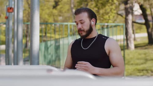 Man Drinking Water After Workout in Park