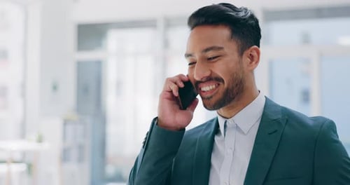 Smiling Businessman Talking on Cellphone in Office